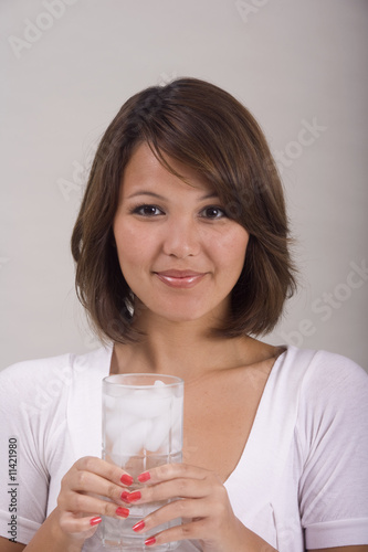 a young Asian-American woman drinking a glass of ice water