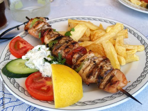 Plate with greek meal pork souvlaki in taverna