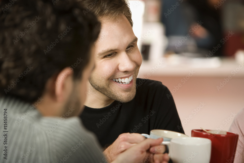 Young Man Toasting with Coffee Cups Young Man Toasting with Coffee Cups