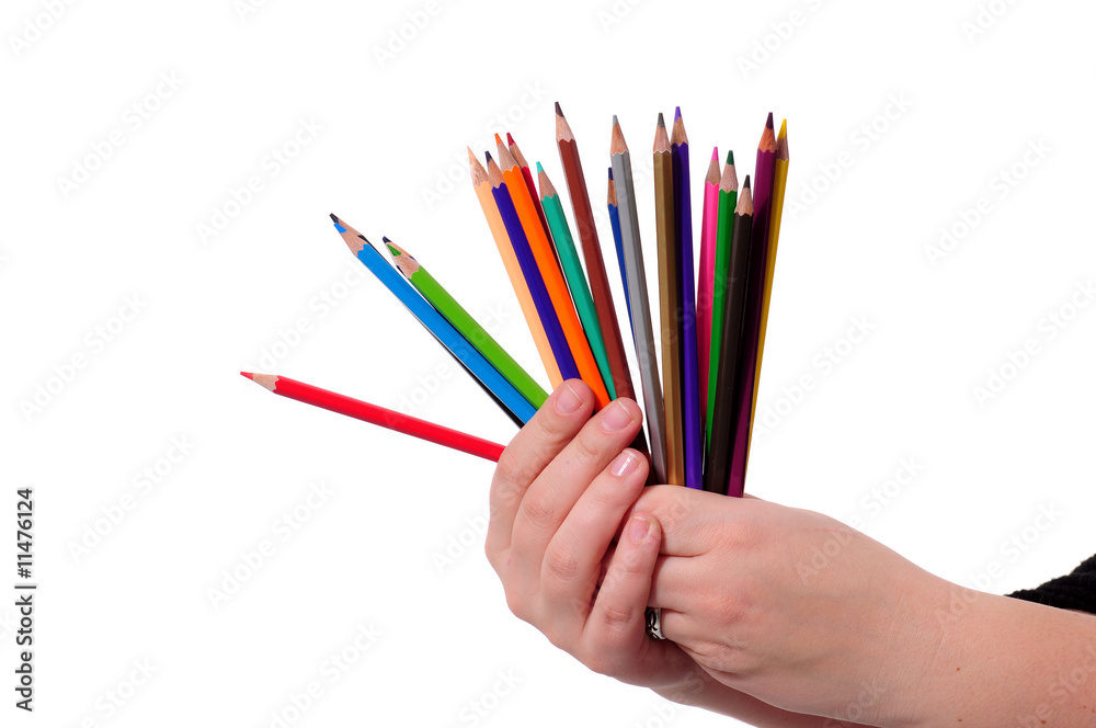 Naklejka premium Hands with colored pencils over white