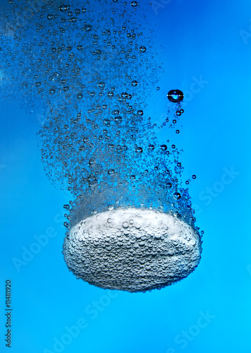 Effervescent tablet in water with bubbles photo
