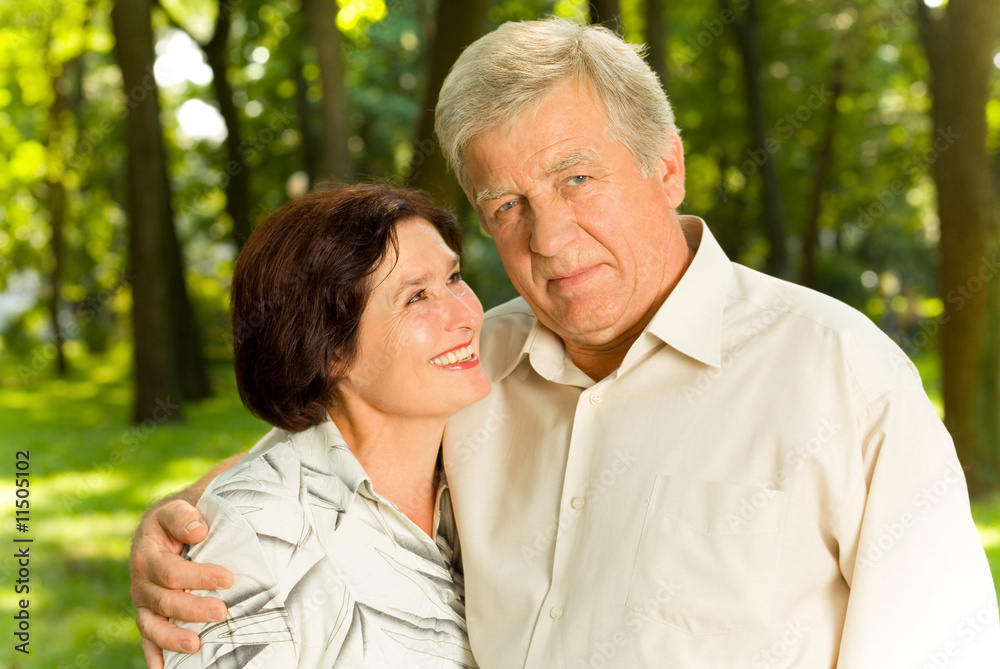 Senior attractive happy couple embracing in park Senior attractive happy couple embracing in park
