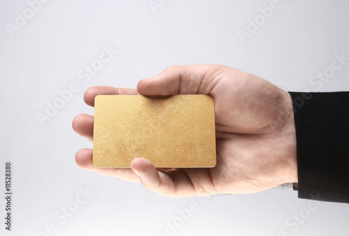 Homem segurando um cartão de negócios dourado