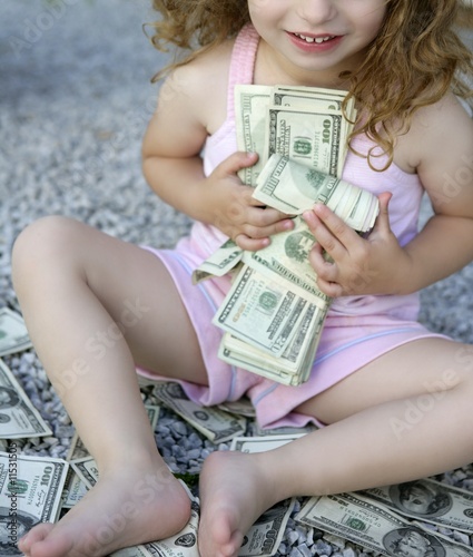 Toddler girl with lots of dollar notes