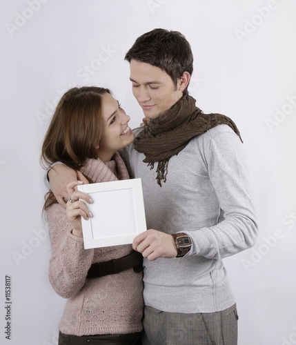 gorgeous couple hugging and holding blank sign