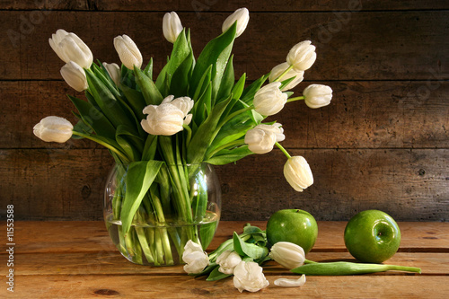 Canvas Print White tulips in glass vase on rustic wood