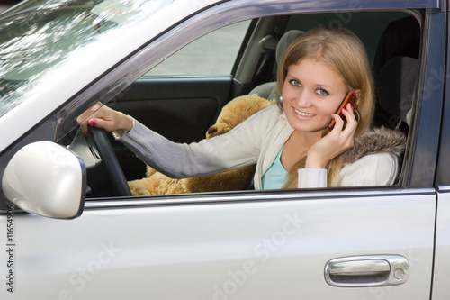 Young woman in her car while on the cell phone
