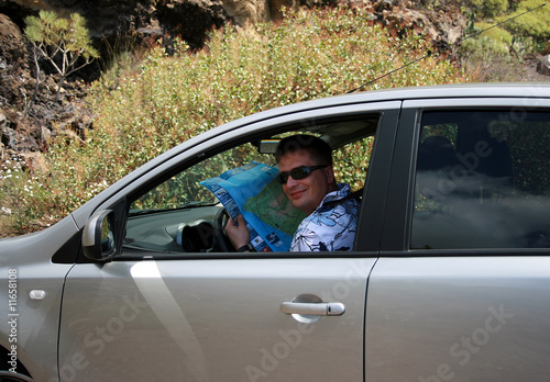 The man in the car with a map  in hands