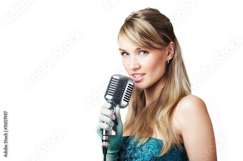 Pretty young girl singing into retro microphone, on white
