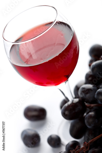 glass of red wine and grapes isolated