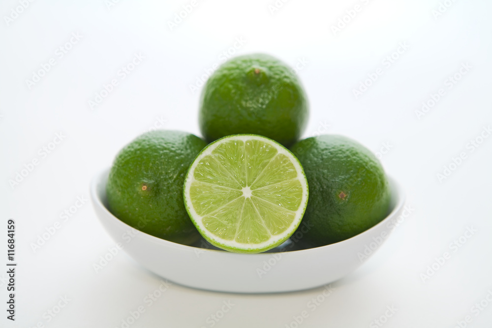 Simple bowl of limes geometrically stacked with white background
