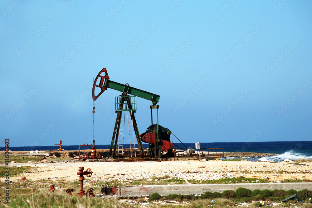 Oil pump jack in work on an ocean or sea coast