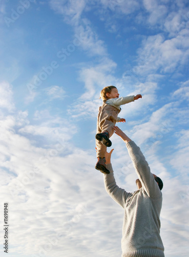 father and son playing on sky background