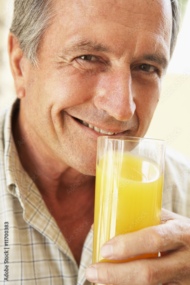 Senior Man Smiling At Camera And Drinking Orange Juice Senior Man Smiling At Camera And Drinking Orange Juice