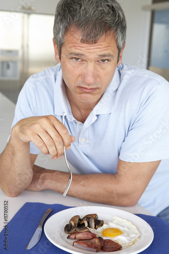 фотографія Middle Aged Man Eating Unhealthy Fried Breakfast