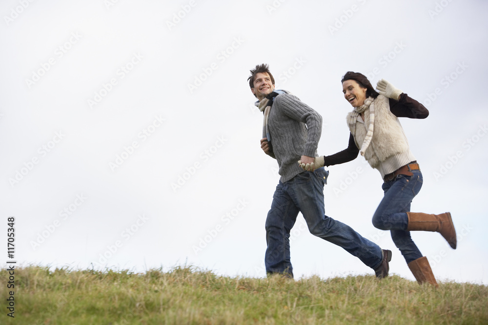 Couple Holding Hands And Running In The Park Couple Holding Hands And Running In The Park