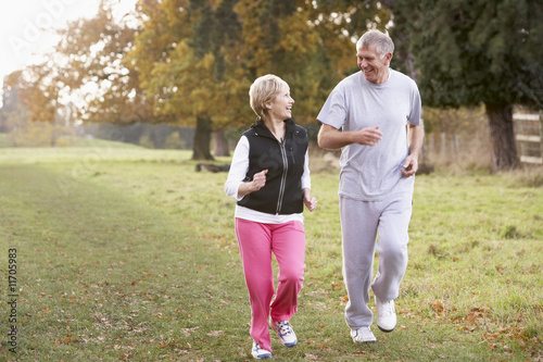 Senior Couple Power Walking In The Park