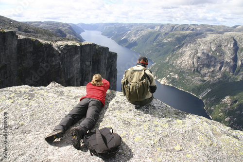 Wanderer bei Pause hoch über dem Lyse Fjord - Norwegen photo