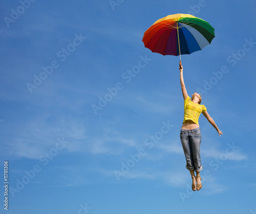Foto Flying girl with colorful umbrella in the blue blue sky