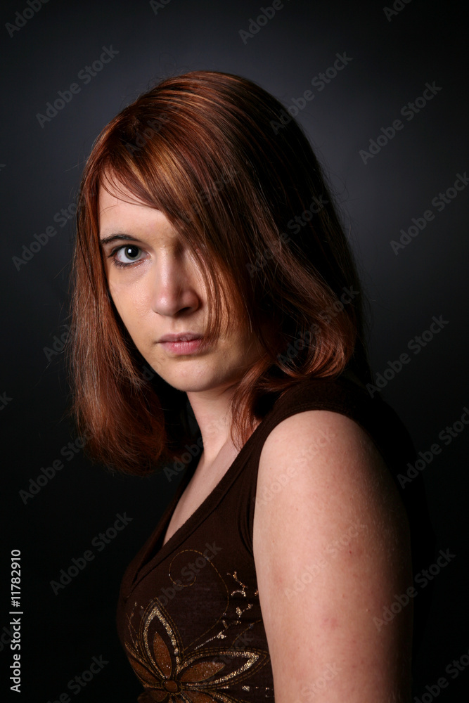 beautiful teenage girl with auburn hair obscuring one eye beautiful teenage girl with auburn hair obscuring one eye