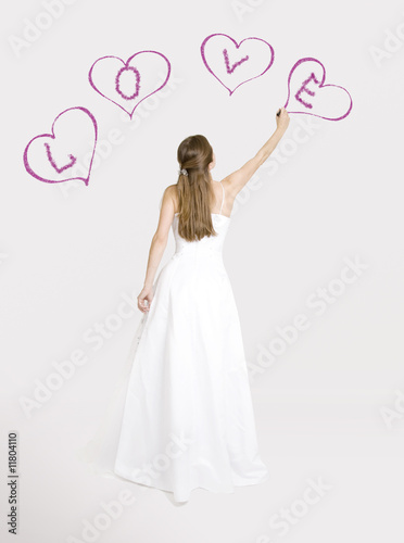 Bride drawing hearts on the wall