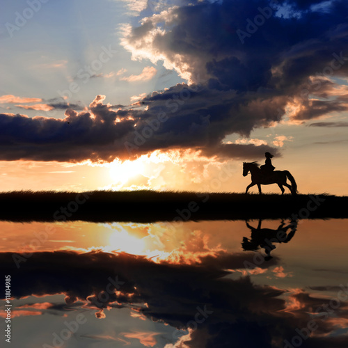 Horseback riding on coastline on sunset