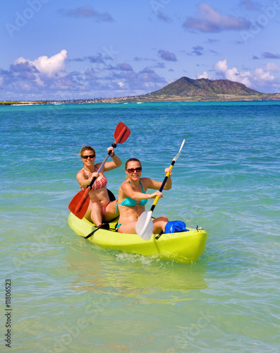 Two sisters paddling a kayak in Hawaii