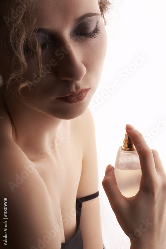 sensual blond woman applying perfume on her body