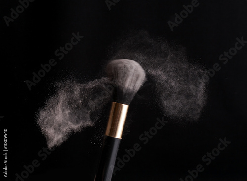 thick black brush and loose powder particles scattered around