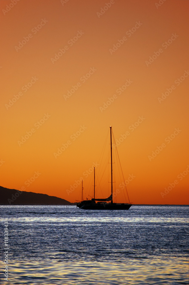 Sun setting behind silhouette yacht, Moorea de Tahiti, Polynesia