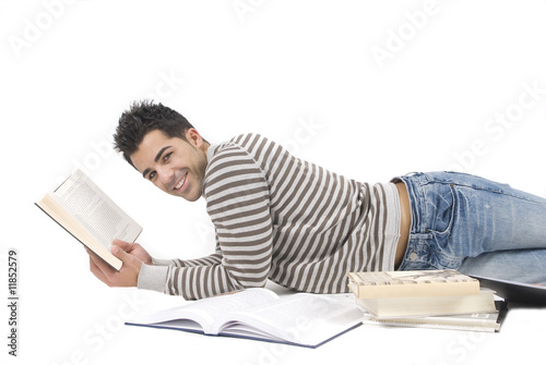 young man reading a book on the floor photo