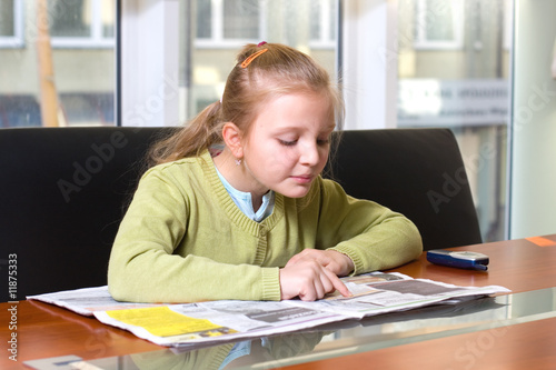 young girl reading newspaper