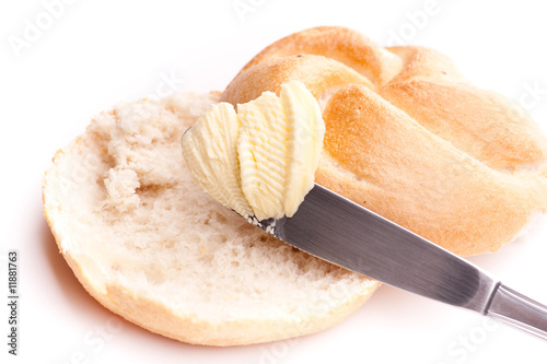 Hälften von Semmel mit Butter und Messer