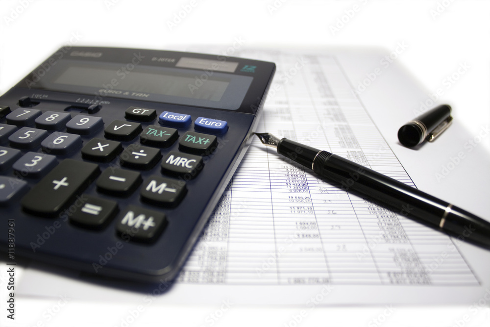 Calculator and pen on balance sheet Calculator and pen on balance sheet