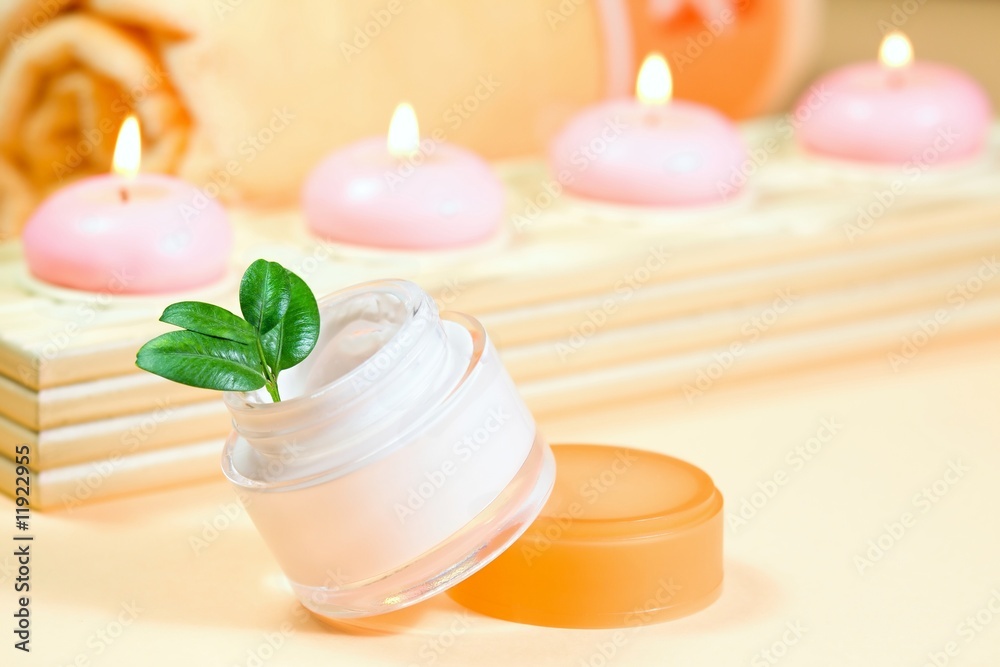 .Moisturizing cream with candles and towel
