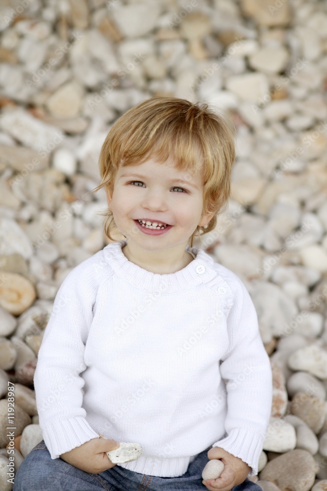 Blond boy smiling on a rolling stones background Blond boy smiling on a rolling stones background
