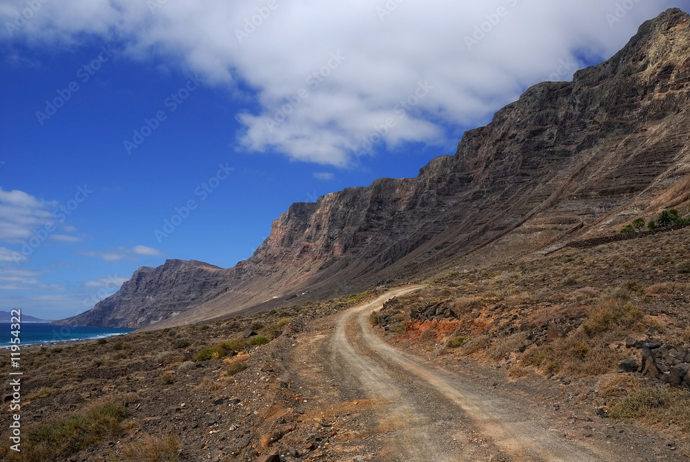 The road between high rocks and ocean