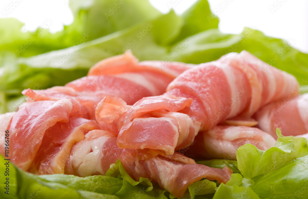 Sliced pork with bacon, lettuce and herbs