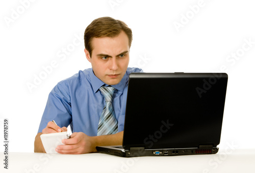 Young businessman working on a laptop. Isolated on white.