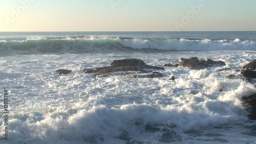Agitated sea waves against rocks in the beach