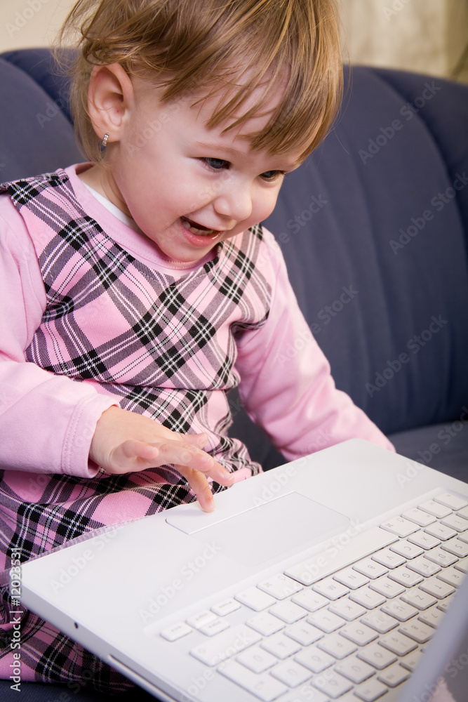Beutiful little girl play with white laptop computer Beutiful little girl play with white laptop computer