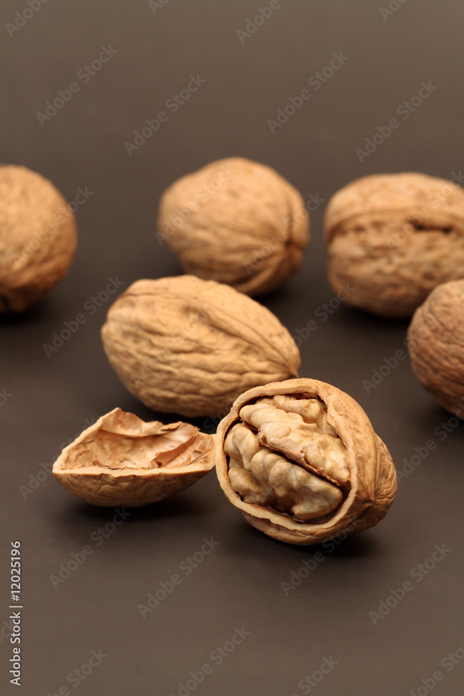 Cracked walnut with nutshell on background with walnuts Cracked walnut with nutshell on background with walnuts