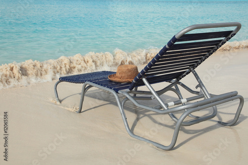 Straw hat  on lounge chair on tropical island beach resort
