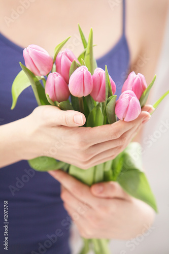 Beautiful hands holding tulips. Soft-focused.