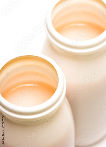 Two jars with milk over white