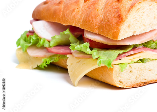 half of long baguette sandwich with bacon, tukey and cheese photo