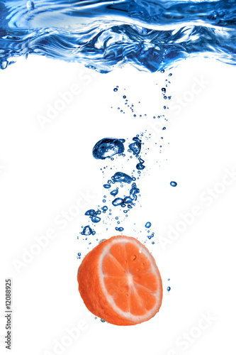 grapefruit dropped into water with bubbles isolated on white