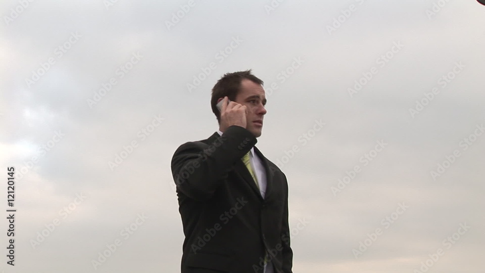 Businessman talking on a mobile phone outdoors Businessman talking on a mobile phone outdoors