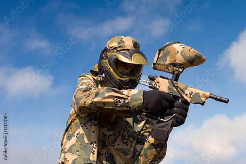 Paintball player over sky background