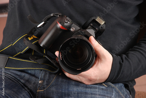 Photographer holding photo camera (digital SLR) in hands